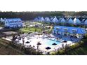 Aerial view of a sparkling community pool surrounded by lounge chairs and umbrellas at 1058 Marsh Harrier Dr # 15-7P, Ravenel, SC 29470