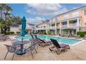 Inviting community pool surrounded by lounge chairs and lush landscaping at 130 River Landing Dr # 7309, Charleston, SC 29492