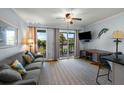 Cozy living room featuring a comfortable couch, ceiling fan and sliding glass doors at 1300 Ocean Blvd # 102 A, Isle of Palms, SC 29451
