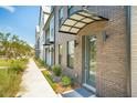 Modern townhome exterior shows brick facade with covered entry, complemented by manicured landscaping along the sidewalk at 1515 Hidalgo Dr, Mount Pleasant, SC 29464