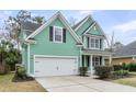 Lovely home featuring green siding, white trim, a well-maintained lawn, and a convenient two-car garage at 2085 Terrabrook Ln, Charleston, SC 29412