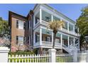 Elegant home exterior featuring grand columns, multiple balconies, and a charming white picket fence at 214 Calhoun St # 5, Charleston, SC 29401