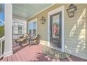 Inviting front porch features comfortable seating, a stylish rug, and a classic glass-paneled door with side lights at 2506 Gatewood St, Charleston, SC 29492