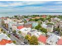 Stunning aerial view of colorful townhouses with rooftop terraces near the ocean, offering luxurious living at 29 Broad St # A C, Charleston, SC 29401