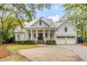 Beautiful traditional home with white siding, metal roof, columned porch, brick steps and a circular driveway at 309 N Civitas St, Mount Pleasant, SC 29464