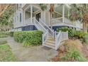 Inviting front porch with stairs, adorned with palm trees and lush landscaping at 4000 Cameron Blvd, Isle of Palms, SC 29451