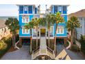 Spectacular beach house boasting a striking blue facade and grand entrance, elevated for breathtaking ocean views and coastal living at 511 W Ashley Ave, Folly Beach, SC 29439