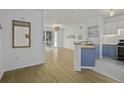 Bright living space featuring wood floors, neutral walls, balcony access, and modern kitchen view at 60 Fenwick Hall Aly # 622, Johns Island, SC 29455