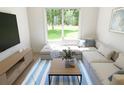Living room with sectional couch and a window view of the landscaped backyard at 7614 Indigo Palms Way, Johns Island, SC 29455