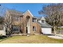 Traditional brick home featuring an attached garage and manicured front lawn at 8512 Kennestone Ln, Charleston, SC 29420