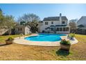 Large backyard pool surrounded by green grass, a shed, and a covered patio at 8512 Kennestone Ln, Charleston, SC 29420