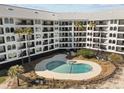 A lovely pool is surrounded by palm trees and multiple balconies in this beachfront condominium complex at 9002 Palmetto Drive #514 1/13 Share, Isle of Palms, SC 29451