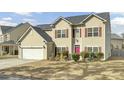 Charming two-story home with a well-manicured lawn and inviting pink front door at 9620 Pebble Creek Blvd, Summerville, SC 29485