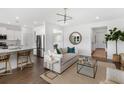 Open-concept living room and kitchen boasts modern lighting, sleek furniture, and hardwood flooring at 103 Pen Shell St, Summerville, SC 29485