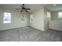 A bright, carpeted room featuring three windows, neutral walls, and a ceiling fan for comfortable living at 1225 Blakeway St # 406, Charleston, SC 29492