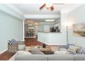 Modern staged living room with wood floors flowing into kitchen and dining area at 1433 Telfair Way, Charleston, SC 29412