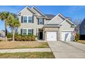 Charming two-story home featuring a manicured lawn, a two-car garage, and an inviting front entrance at 146 Stagecoach Ave, Summerville, SC 29486