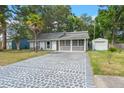 Well-maintained home with a long driveway, screened-in porch, and storage shed at 204 Tram Blvd, Summerville, SC 29486
