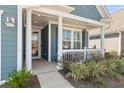 A close up of the front porch of a home with columns and attractive landscaping at 222 River Martin Ct, Summerville, SC 29483