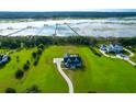 Beautiful aerial view of the modern farmhouse estate highlighting its pristine landscaping, water access, and proximity to other homes at 2621 Anchor Watch Dr, Wadmalaw Island, SC 29487