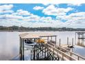Private boat dock featuring a boat lift, kayaks, and direct access to the waterway for boating and recreation at 2621 Anchor Watch Dr, Wadmalaw Island, SC 29487