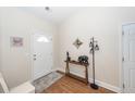 Bright entryway with white door, wood console table, and laminate wood flooring at 322 Freeland Way, Moncks Corner, SC 29461