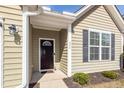 Close up of the front door, with sidelight window, olive siding, and black shutters at 322 Freeland Way, Moncks Corner, SC 29461