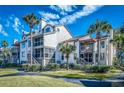 Condo exterior with balconies, palm trees, well-maintained landscaping, and inviting walkways at 401 Yacht Harbor Ct, Isle of Palms, SC 29451