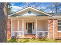 Inviting front porch with classic white columns, brick foundation, and front door at 407 Hayne St, Walterboro, SC 29488