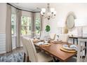 Elegant dining room with stylish chandelier, wainscoting, and a table set for a meal at 593 Red Monarch Way, Moncks Corner, SC 29461