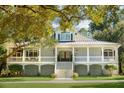 Traditional two-story home boasting a large wrap-around porch, grand entrance, and manicured front yard at 5991 Joseph Blake Ln, Wadmalaw Island, SC 29487