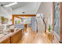 Inviting living room with vaulted ceilings, skylights, and hardwood floors leading to a modern kitchen at 619 E Erie Ave, Folly Beach, SC 29439