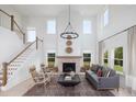 Bright living room with vaulted ceilings, large windows, fireplace, and open staircase at 641 Cottage Landing Dr, Summerville, SC 29485