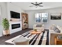 Bright living room with a ceiling fan, modern furniture, fireplace, and a large window at 669 Silver Spruce St, Summerville, SC 29486