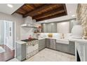 Modern kitchen with stainless steel appliances, farmhouse sink, and wood beam ceiling at 100 Queen St, Charleston, SC 29401