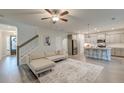 Bright, open-concept living room featuring hardwood floors, stairs, and a modern ceiling fan at 109 Forest Springs Rd, Moncks Corner, SC 29461