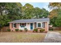 Cozy single-story home with a brick and white siding exterior, surrounded by mature trees at 1491 Seacroft Rd, James Island, SC 29412
