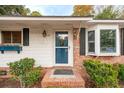 Inviting front entry featuring a blue storm door, brick steps, and manicured landscaping at 1491 Seacroft Rd, James Island, SC 29412