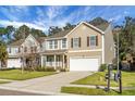 Inviting two-story home with tan siding, well-kept lawn, and a convenient two-car garage at 212 Medford Dr, Summerville, SC 29485