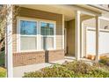 Close-up of charming brick-base front porch with white columns and large double windows at 212 Medford Dr, Summerville, SC 29485