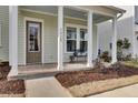Inviting covered front porch with classic columns, brick flooring, and a cozy seating area at 2425 Giles Ln, Mount Pleasant, SC 29466