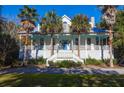 Inviting two-story home with a classic front porch and mature landscaping at 2514 Myrtle Ave, Sullivans Island, SC 29482