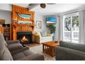 Cozy living room features a wood-burning fireplace, comfortable seating, and a sliding glass door to a private balcony at 278 Driftwood Ln, Edisto Island, SC 29438