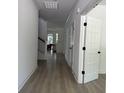 Bright hallway with white trim, wood-look floors, and view of stairs and game room at 2988 Lodge Berry Ln, Johns Island, SC 29455