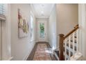 Bright hallway with wood floors, a decorative rug, and a staircase leading to the upper level of the house at 3092 Emma Ln, Mount Pleasant, SC 29466