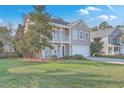 Charming two-story home with a front porch, a second story balcony and a green lawn at 339 Cicadas Song, Moncks Corner, SC 29461