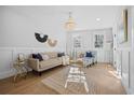 Bright living room featuring hardwood floors, modern furniture, and a stylish chandelier creating an inviting ambiance at 42 Kennedy St, Charleston, SC 29403