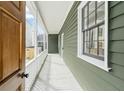 Inviting front porch with white railing, green siding, and natural light streaming through windows at 5 Maranda Holmes St, Charleston, SC 29403