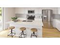 Bright kitchen featuring white cabinets, stainless steel appliances, and an island with seating at 609 Garden Flora Ave, Moncks Corner, SC 29461