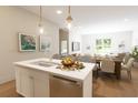 Kitchen island with fruit basket, stainless steel appliances, and pendant lighting at 7626 Indigo Palms Way, Johns Island, SC 29455